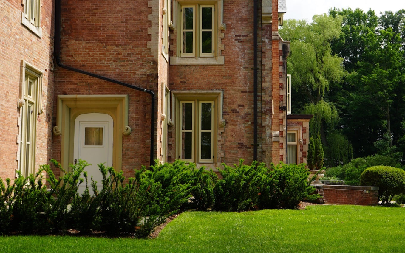 Grand European Manor surrounded by lush green hedges