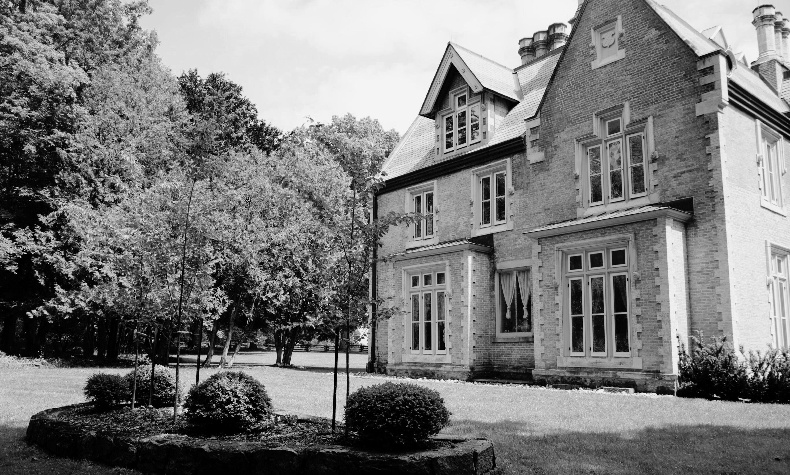 A beautifully landscaped property with a European manor as the centerpiece, showcasing the elegance and sophistication of classic historic design.